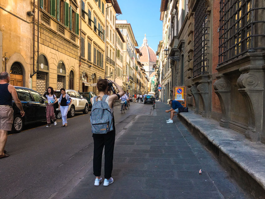 A girl photographing the Duomo from a distance