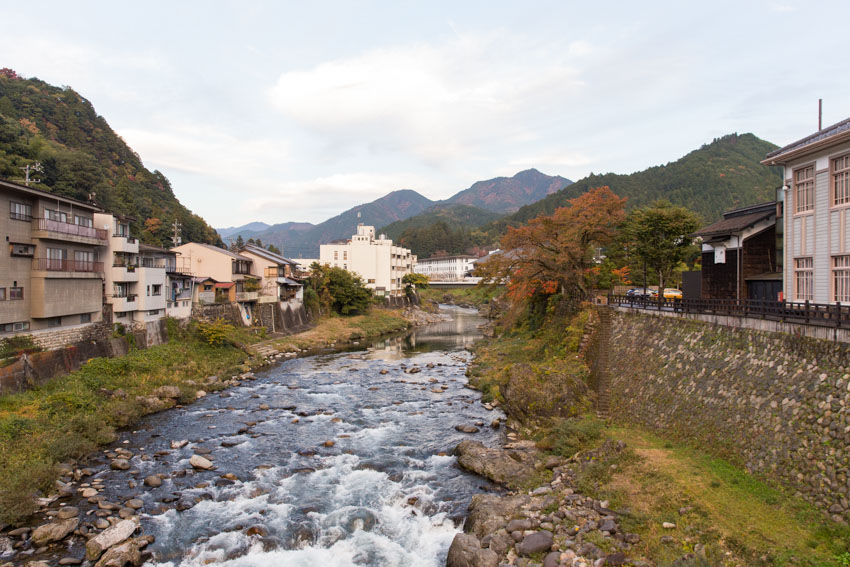 A river view with a lot of large rocks mid-stream