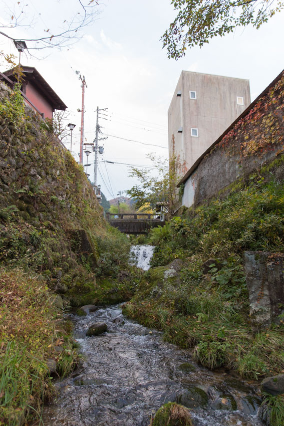 A distant view of a small bridge over a small stream, which leads into the main river