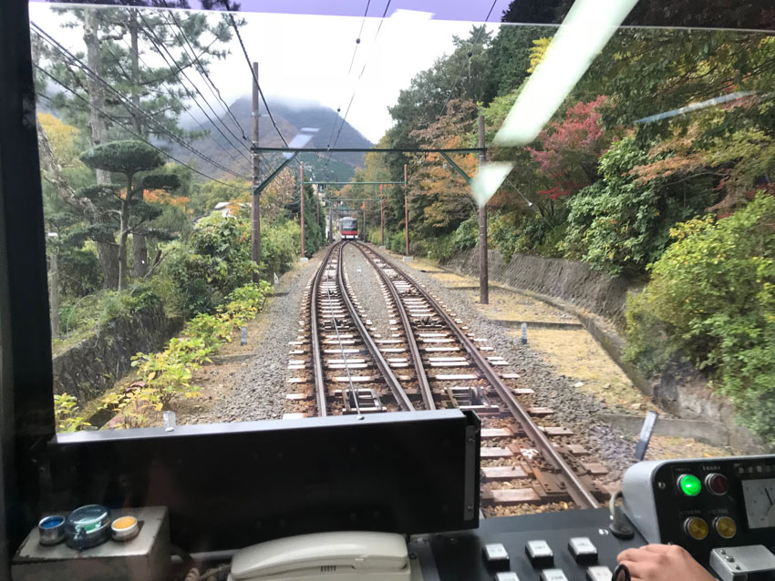 A section of track that splits into two before meeting again, at which point a train coming from the opposite direction is visible