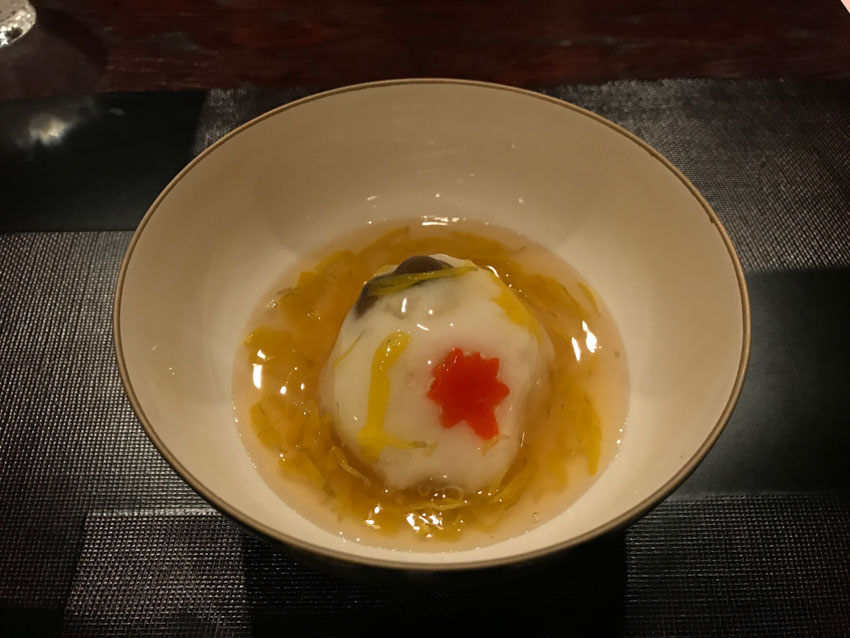 A bowl with a grated turnip ball mixed with mushroom, in a thick soup