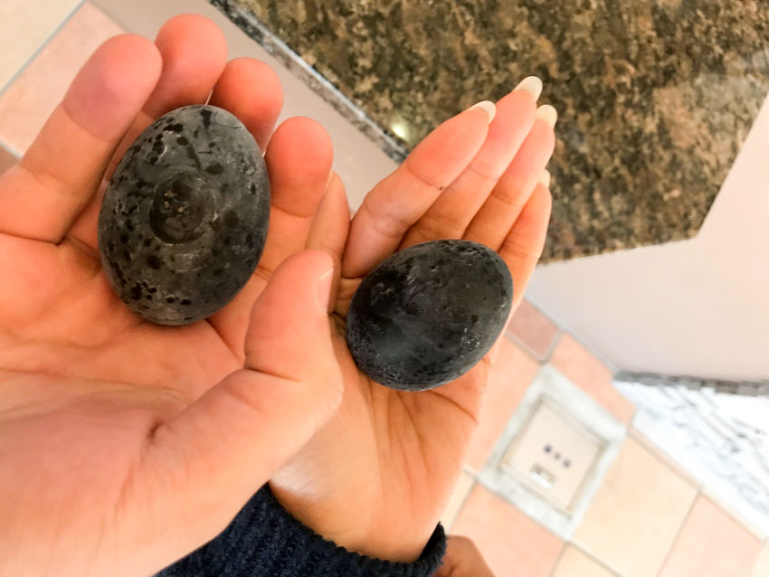 Me and Nick’s hands holding black-shelled eggs cooked in the hot springs