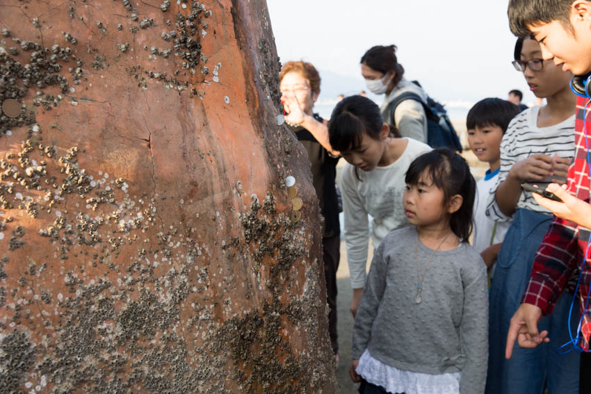 People observing some of the effects of the ocean water on the shrine