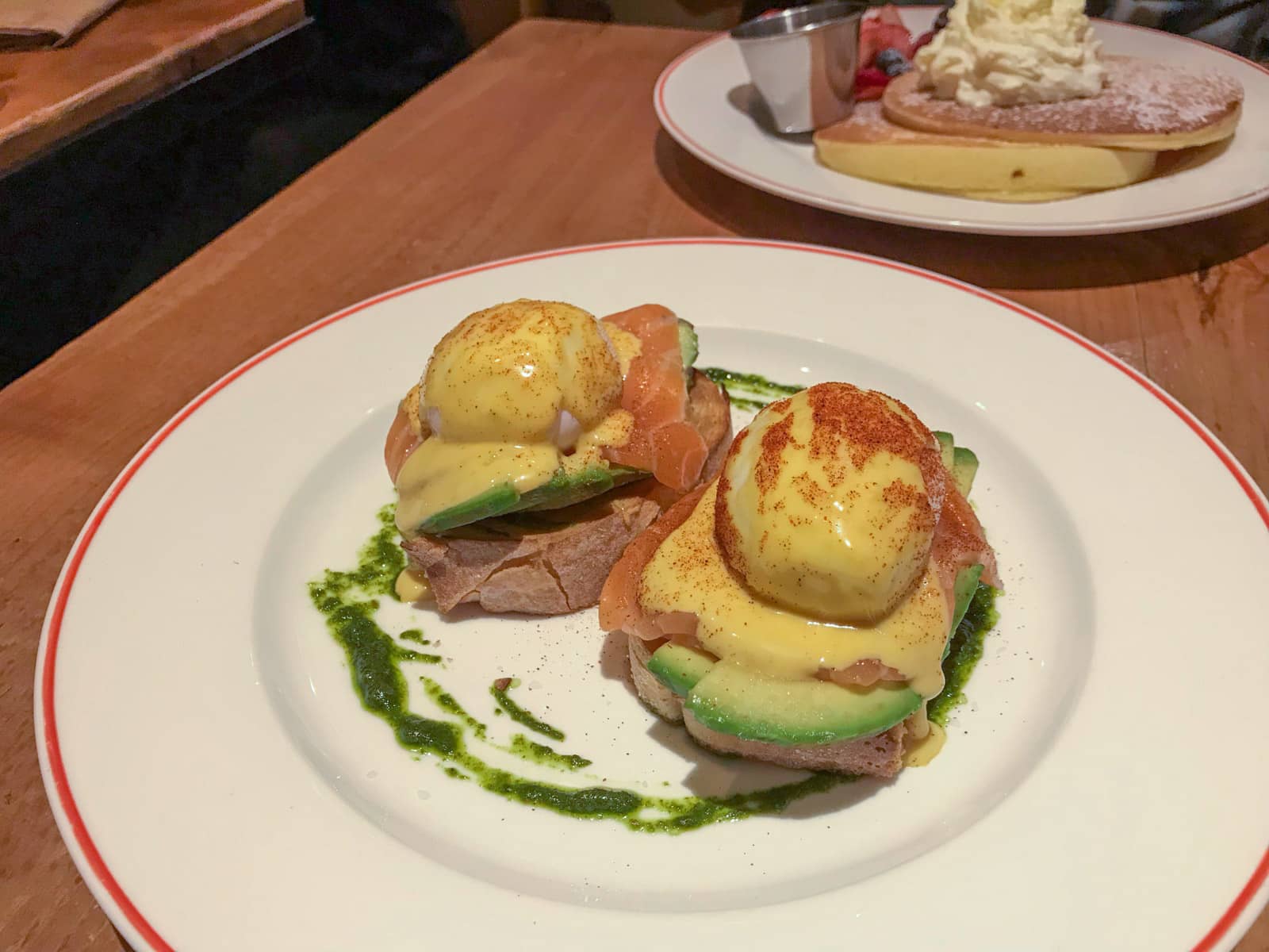 Salmon eggs benedict served on a plate (poached egg with hollandaise sauce, with smoked salmon and avocado on toast)