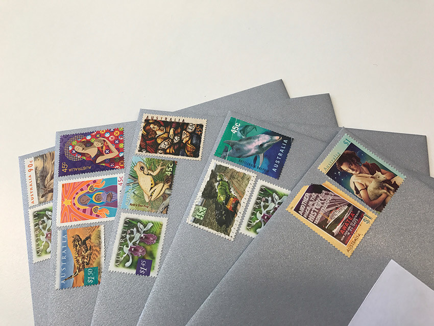 A close up view of post stamps on a fanned-out pile of envelopes.