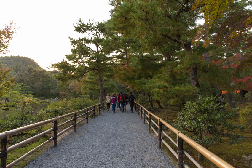 Some tourists walking through a path, seen from a distance