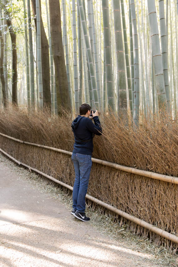 Nick leaning over the barrier on tiptoe with his camera to get some good photos