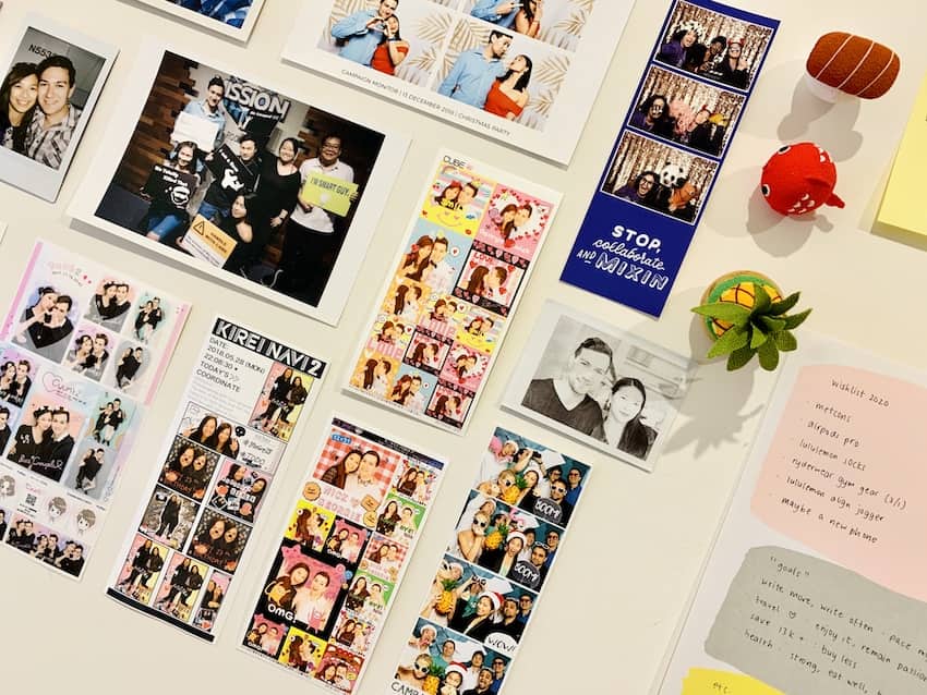 An angled photo of some photos and notes organised neatly on a wall, with some foam decorations tacked onto the wall as well