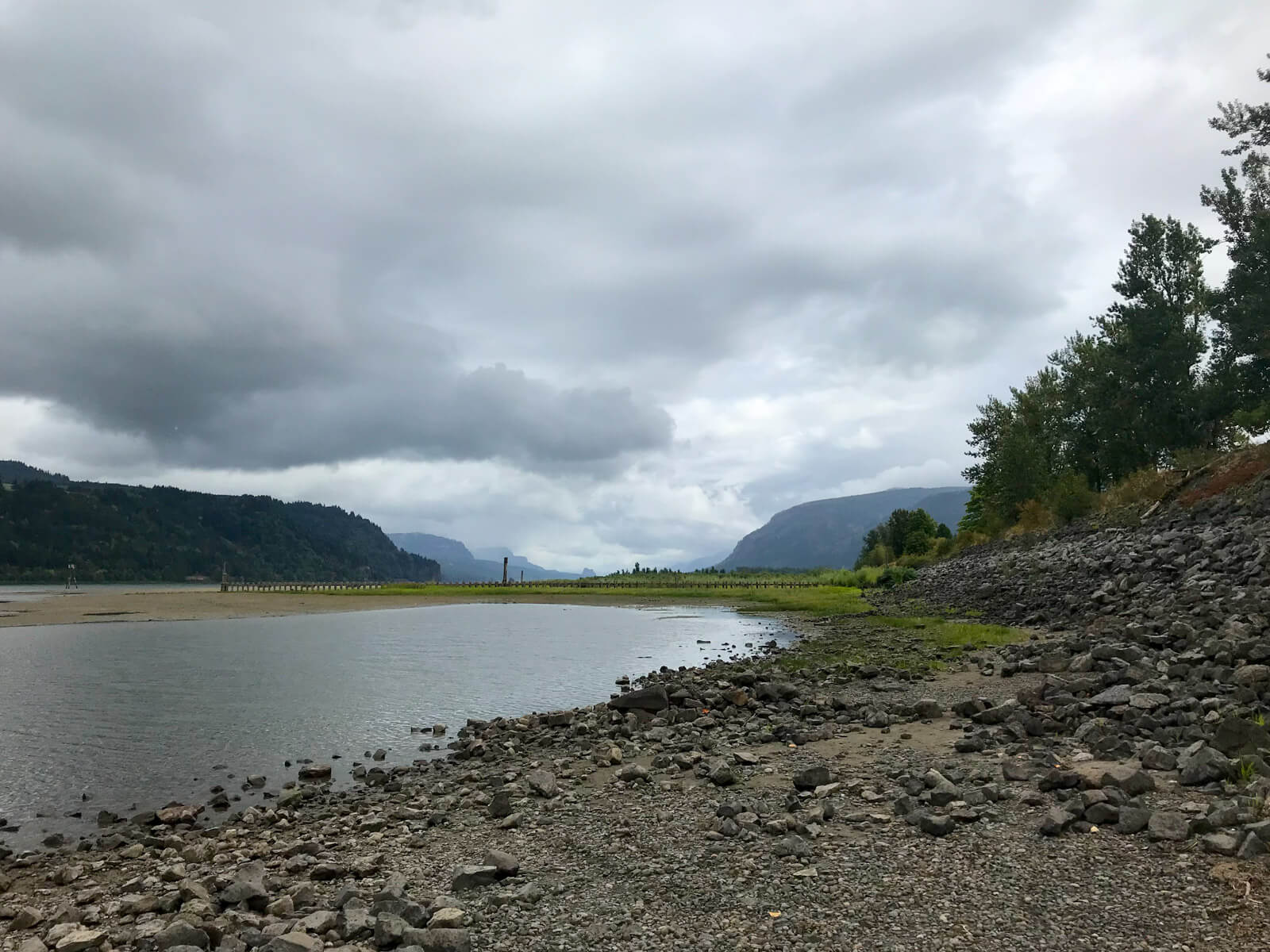 The same rocky area with shallow water, from the previous image, but in a different part of the area, with mountains visible in the distance