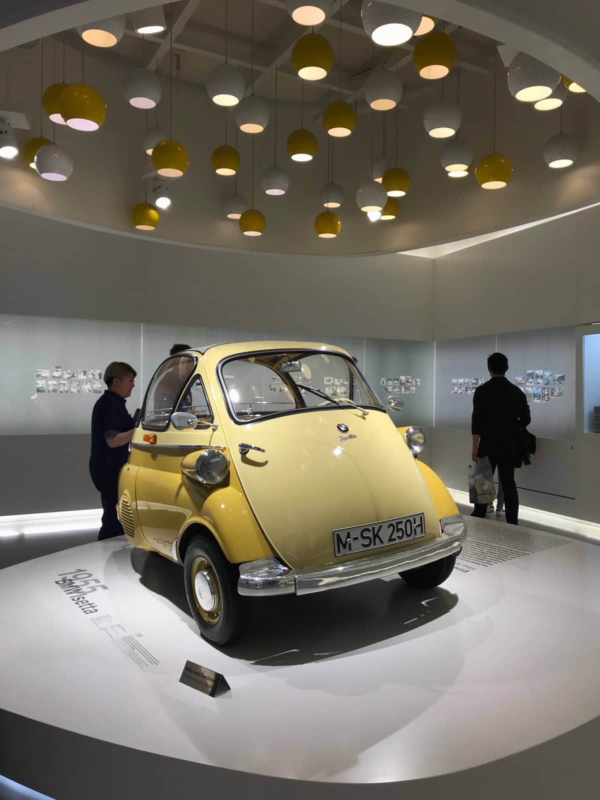 A small yellow car on display inside a museum