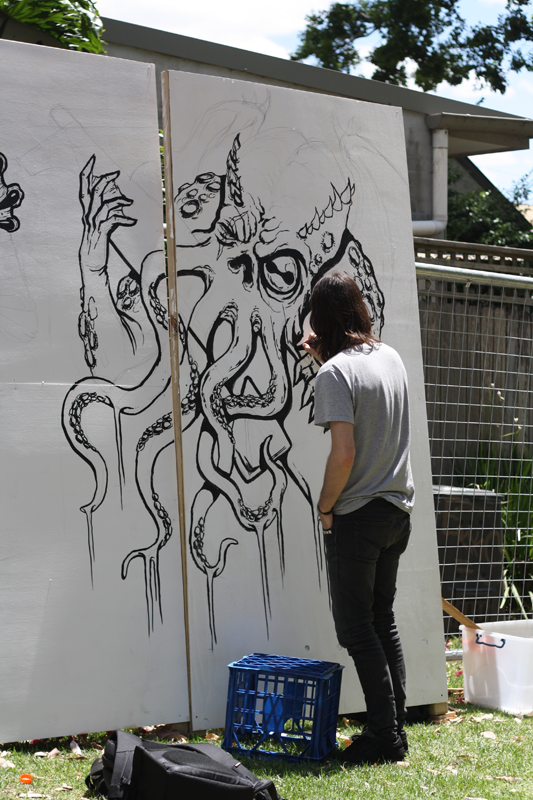 A young man painting artwork on a giant canvas