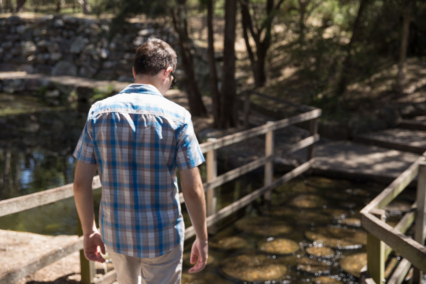 Me facing away from the camera about to cross a bridge of stepping stones