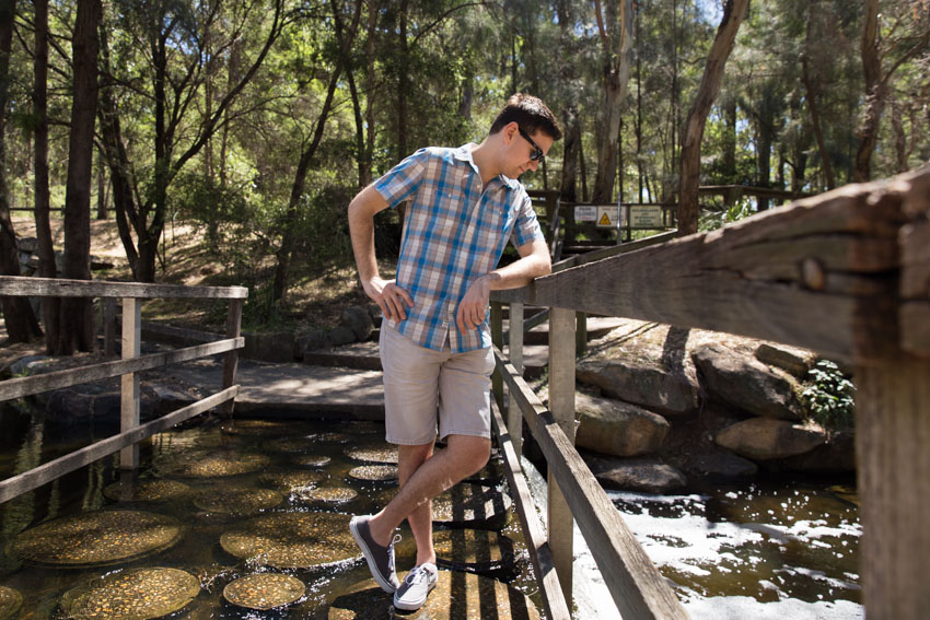 Leaning on the wooden frame of the side of the bridge