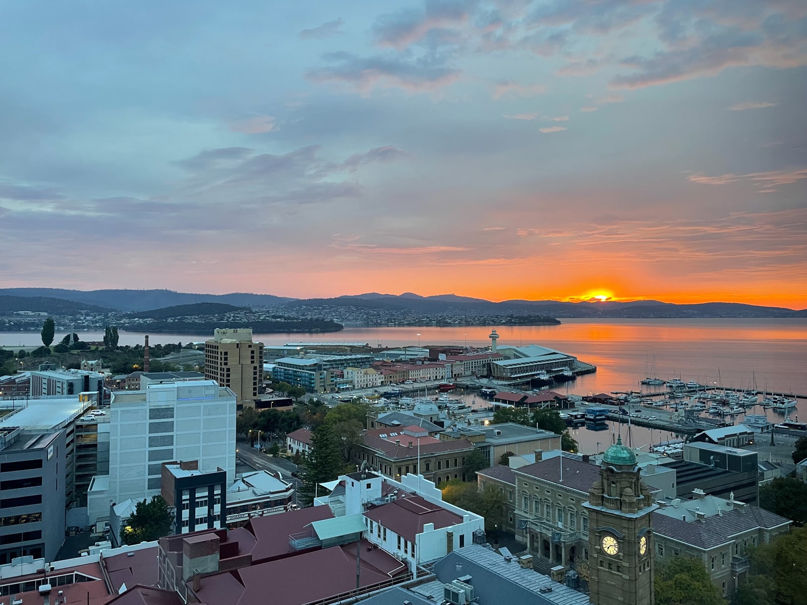 A very orange sunrise seen from a high rise building in Hobart, Australia