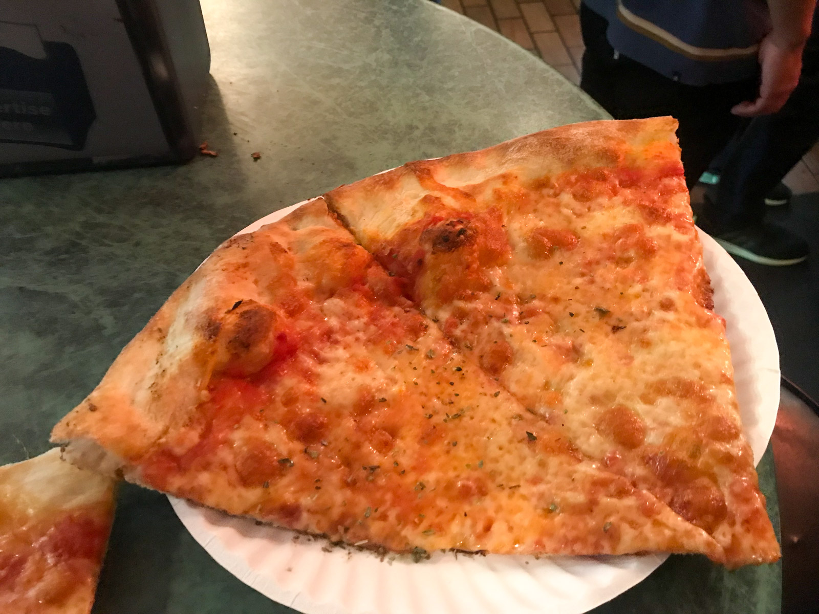 A few slices of cheese pizza on a white paper plate