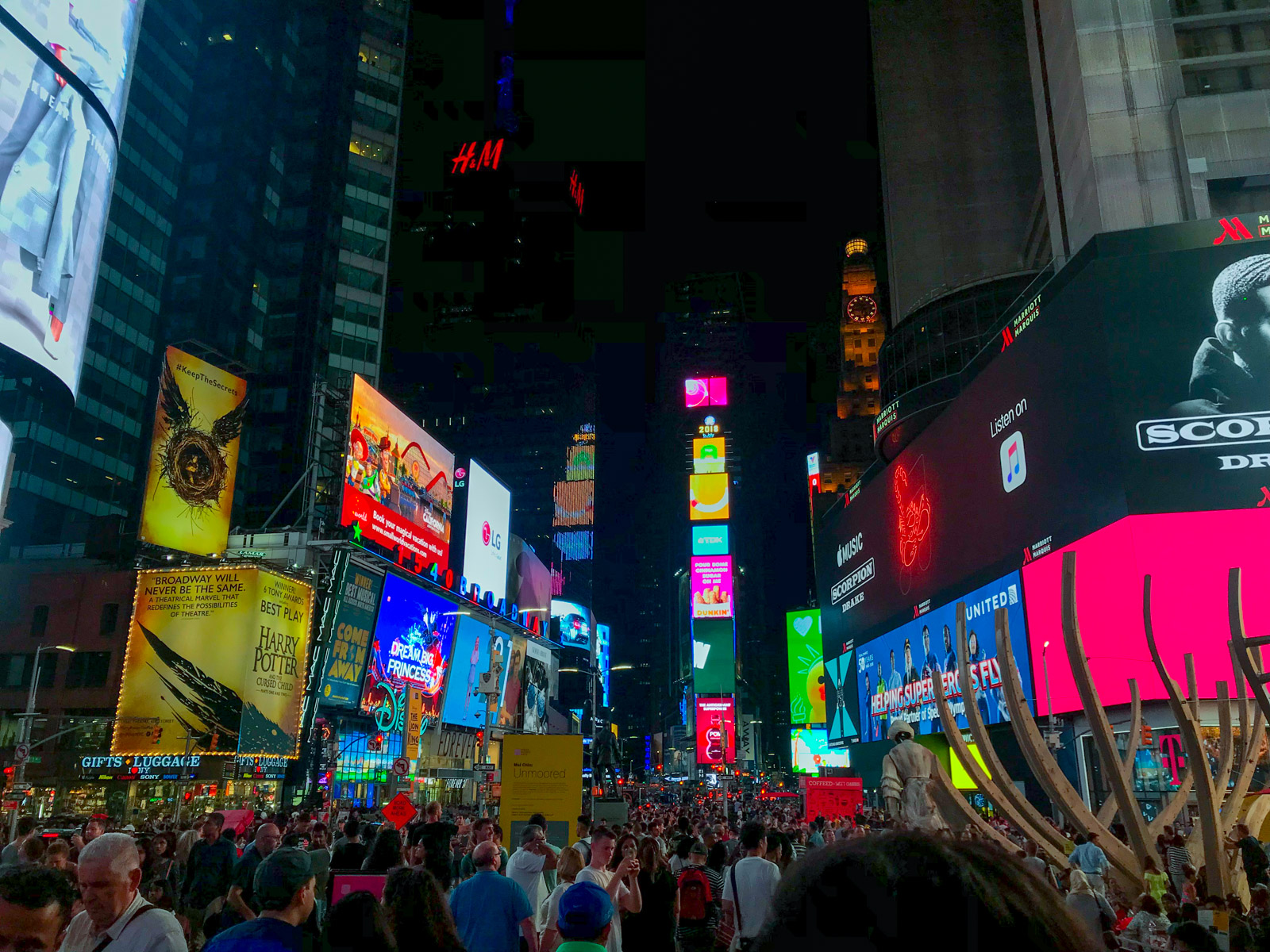 A very busy street with giant, colourful lit-up billboard advertisements