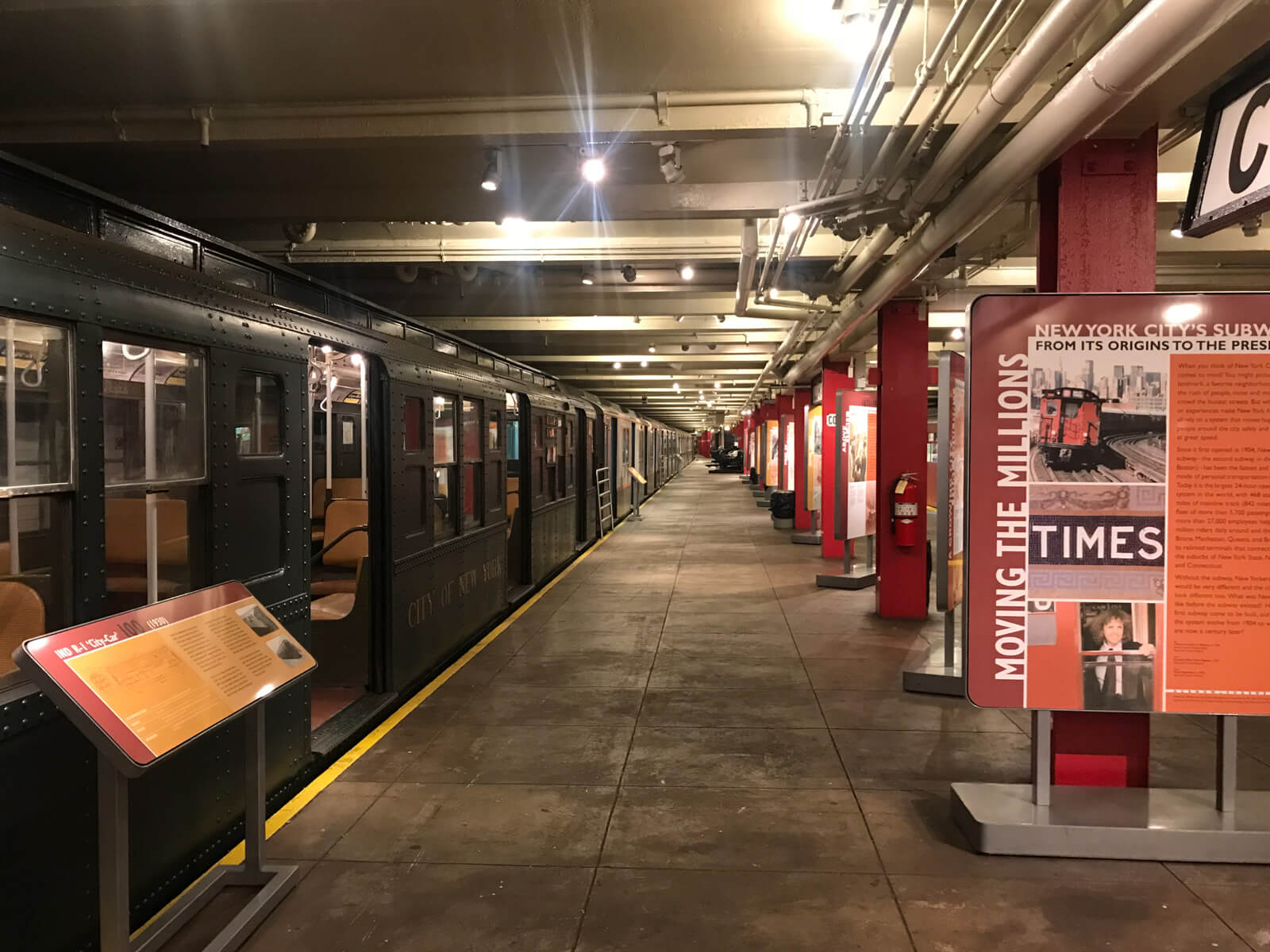 A train station refurbished like a museum. Signs on the platform describe the exhibits, and retired train carriages on the tracks are the features of the exhibit