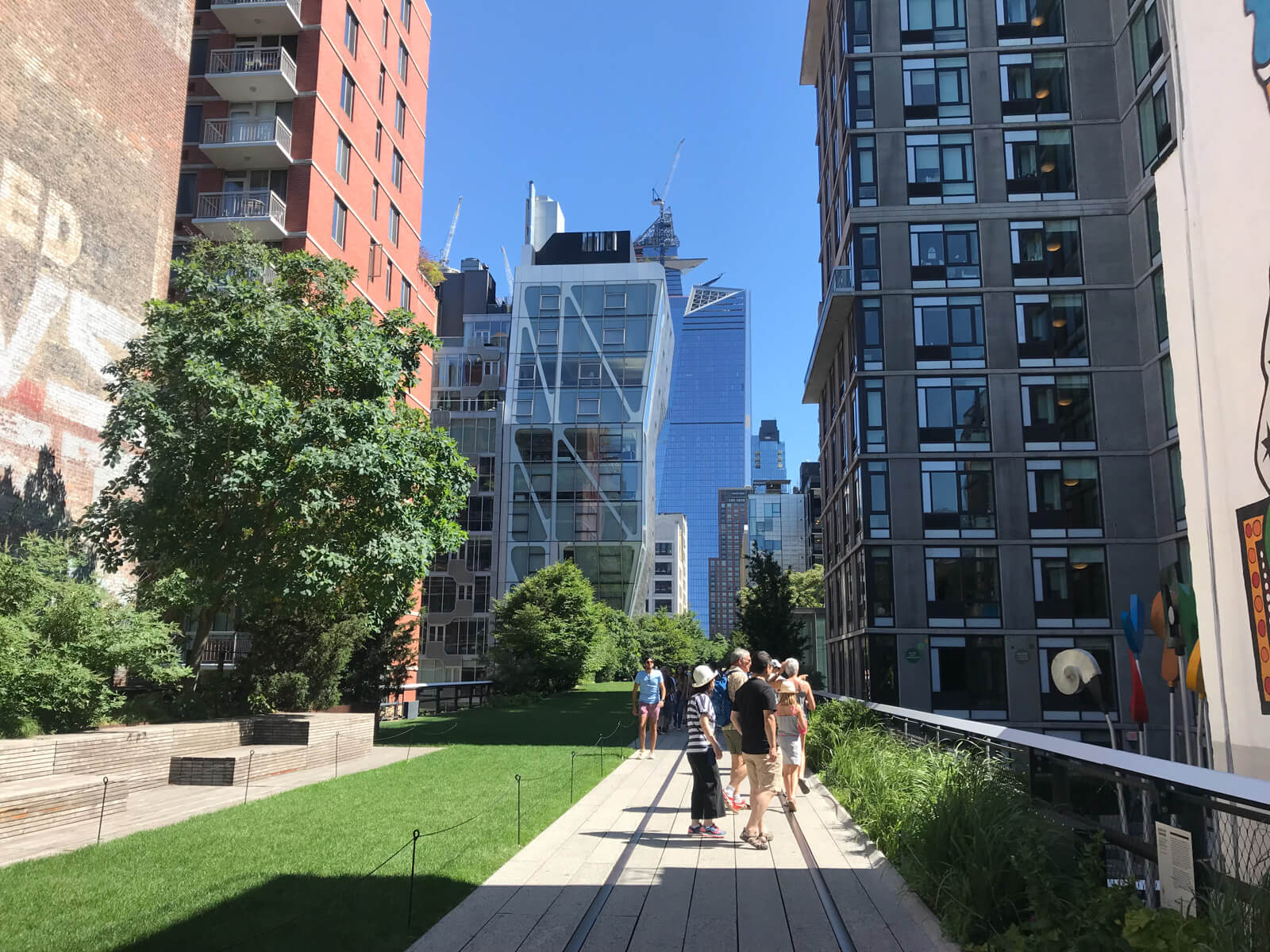 Another angle of the elevated path in the previous photo, showing a clean grass area to the left and a more modern building in the background