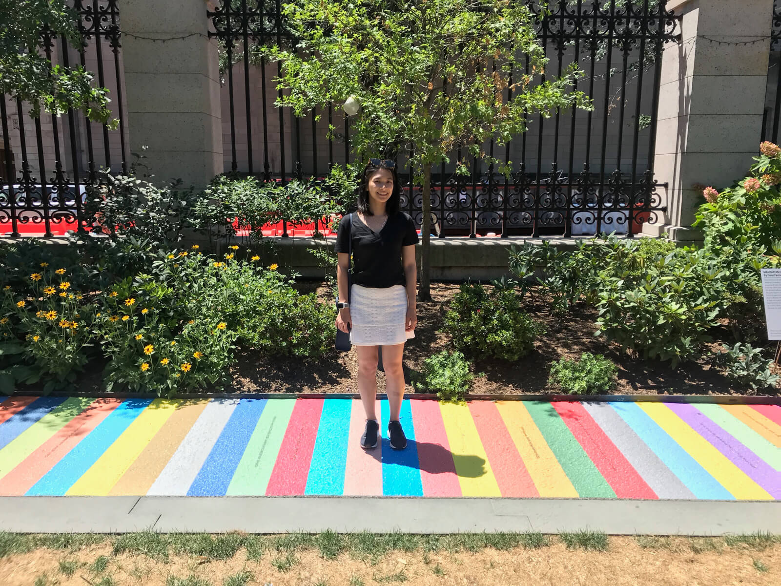 The same scene as the previous photo, with a woman standing on the striped walk. She is wearing a black t-shirt and white skirt.