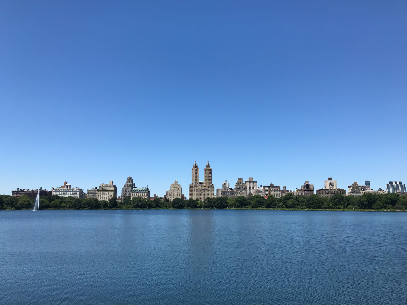 A lake with buildings and trees spread out horizontally in the distance