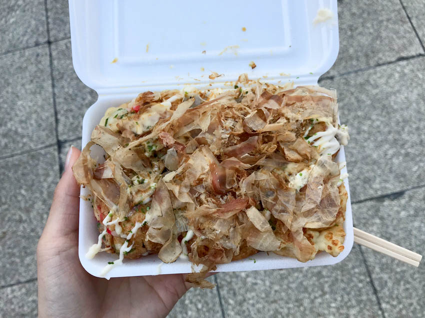 A takeaway box of takoyaki