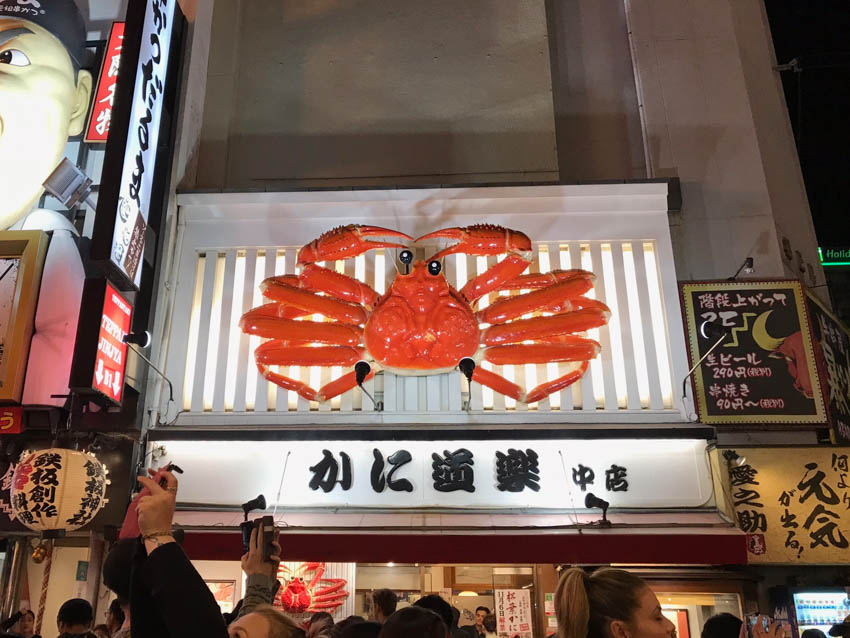 A moving crab sculpture above a store