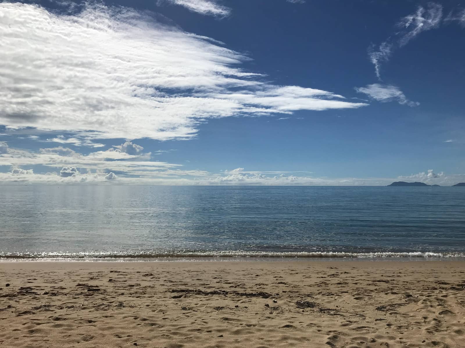 A view of a beach, looking straight out at the water