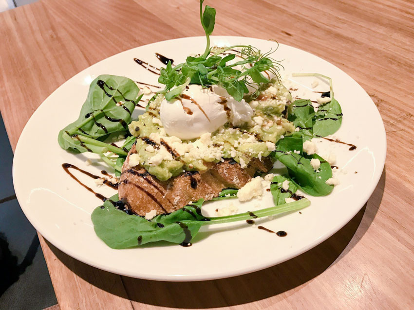 Smashed avocado on sourdough with spinach and a poached egg