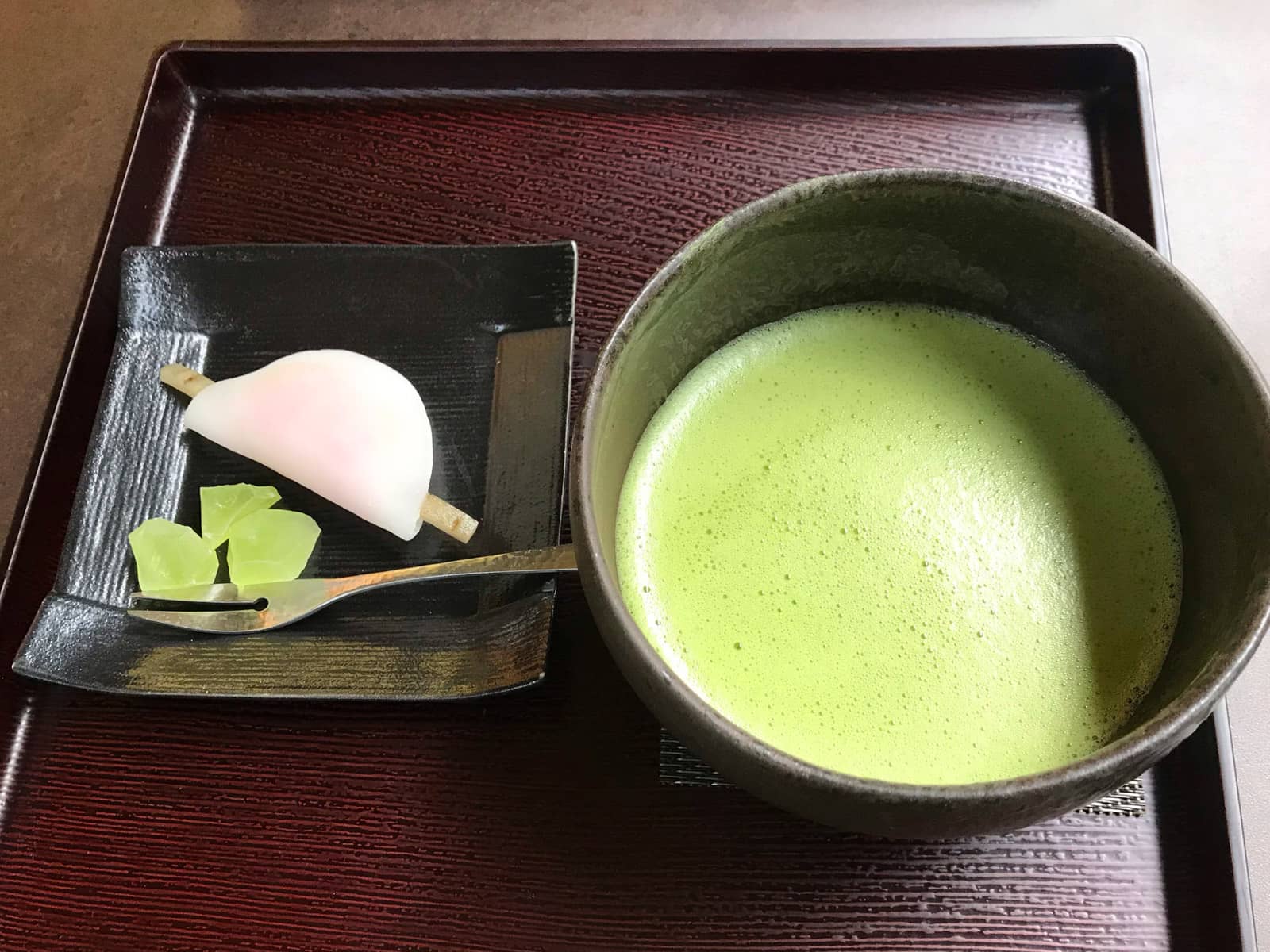 A tray served with green tea matcha and some sweets