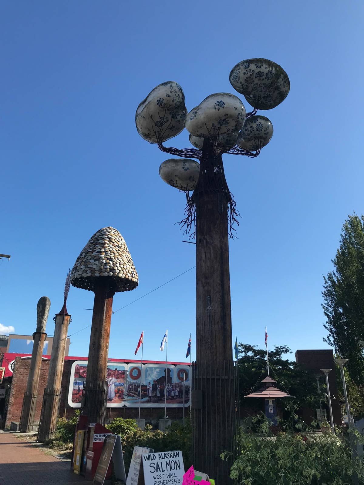 Some tall sculptures with mushroom tops, in the middle of an open park.