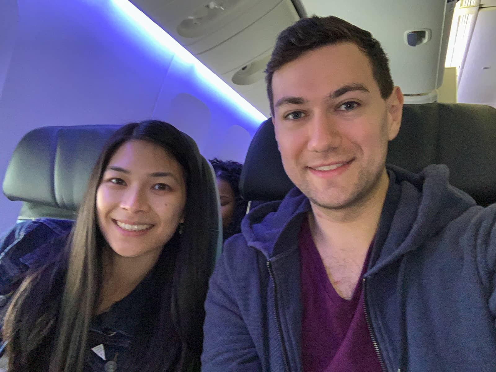 A selfie of a man and woman on a plane, smiling