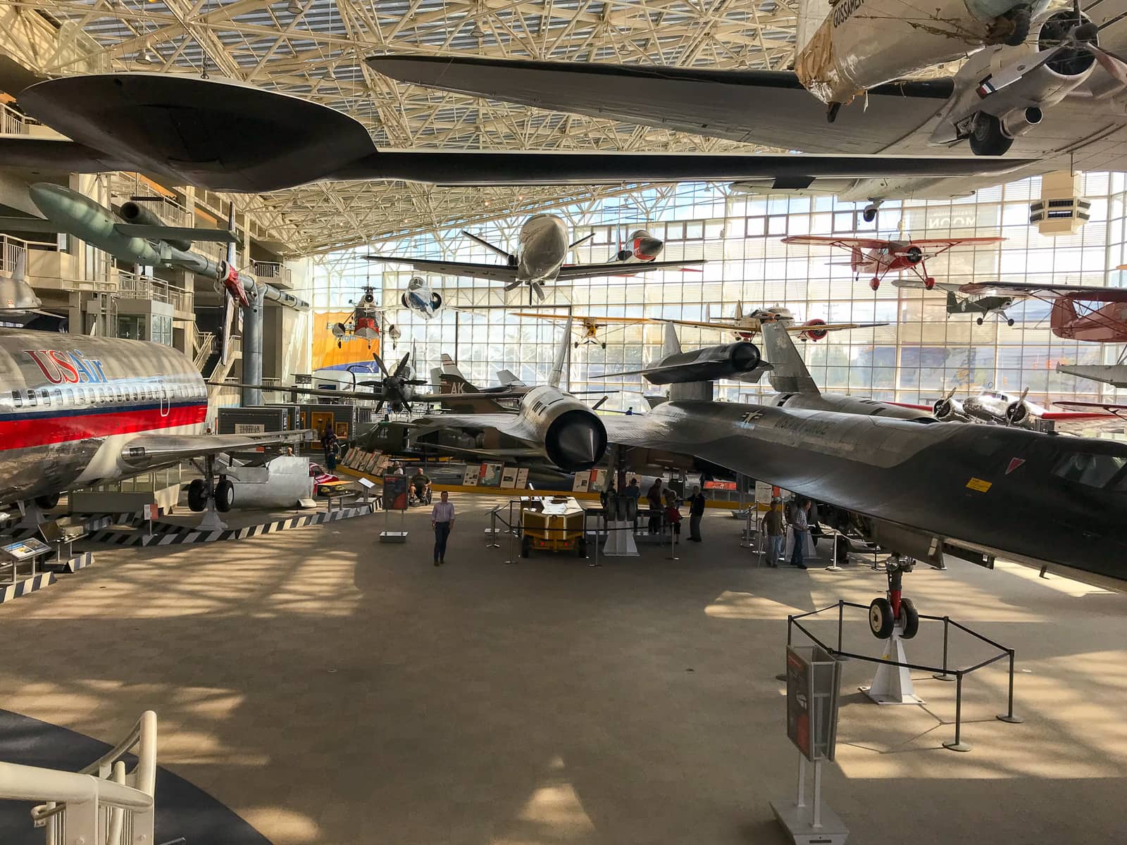 A big room with many lifesize models of airplanes on display, some hanging from the roof