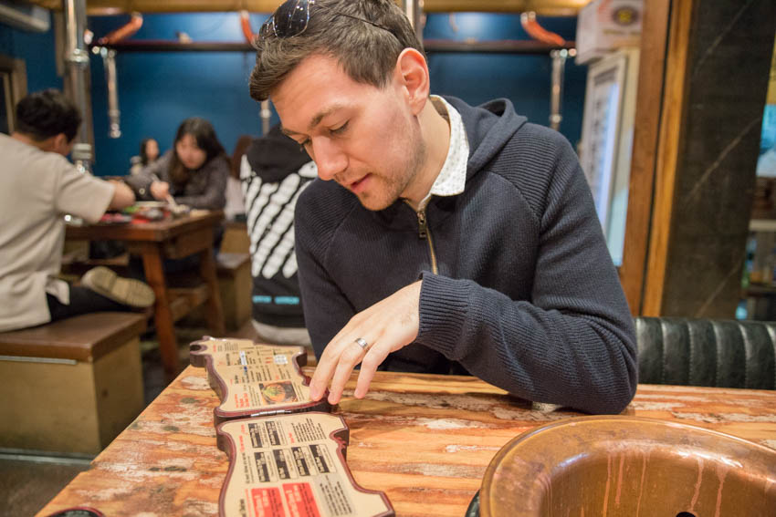 Nick perusing a cow-shaped menu at a barbecue restaurant