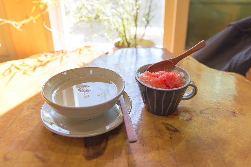 Fermented rice tea in a bowl next to the grapefruit ice tea