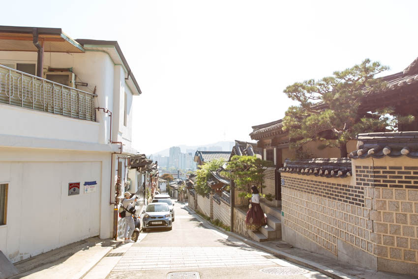 A man taking a photo of a girl in one of the streets of Bukchon village