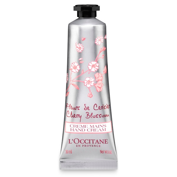 A silver tube of hand cream labelled cherry blossom scent and branded L’Occitane