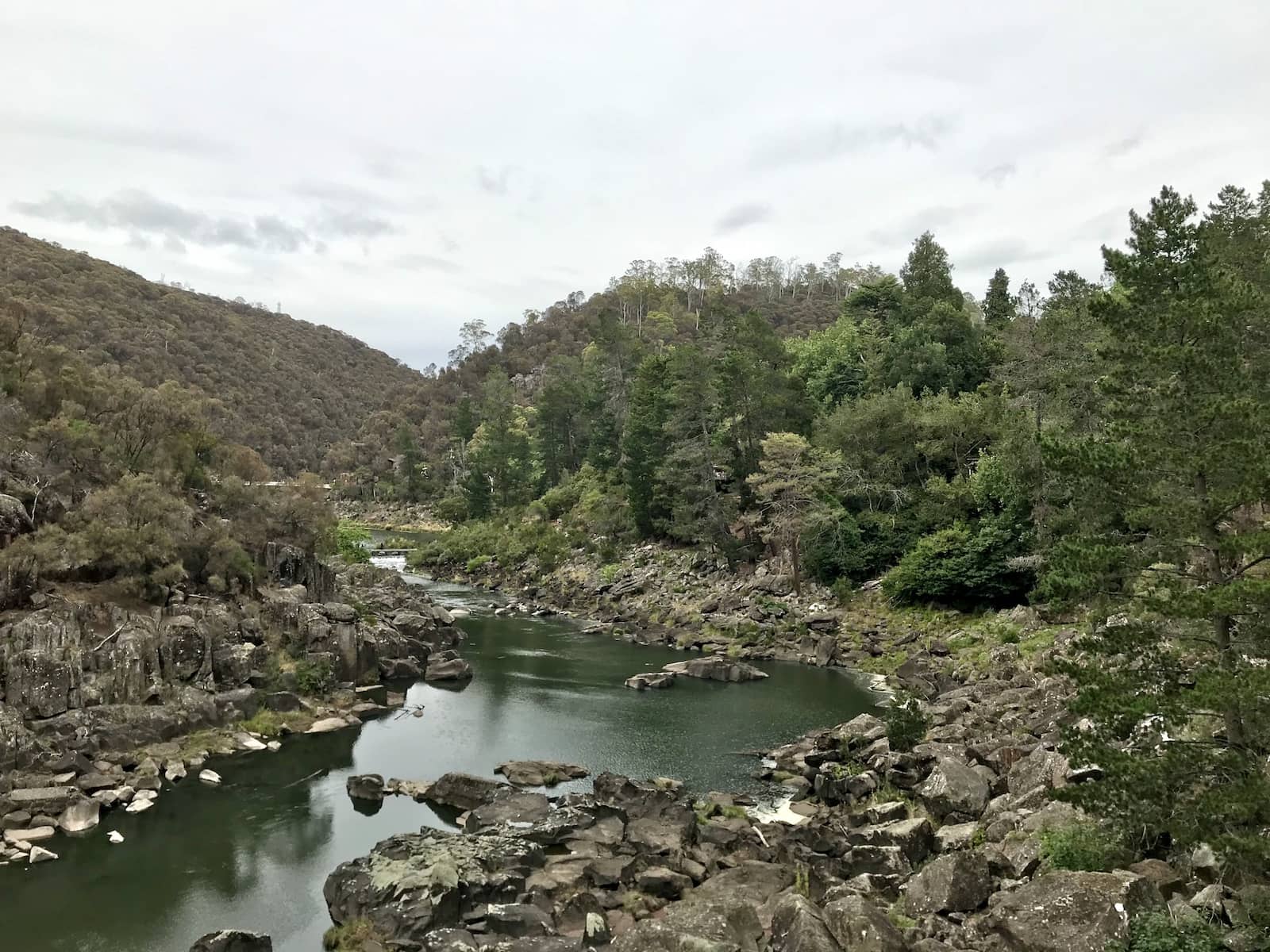 A river running between rocky shores, and plenty of green vegetation around