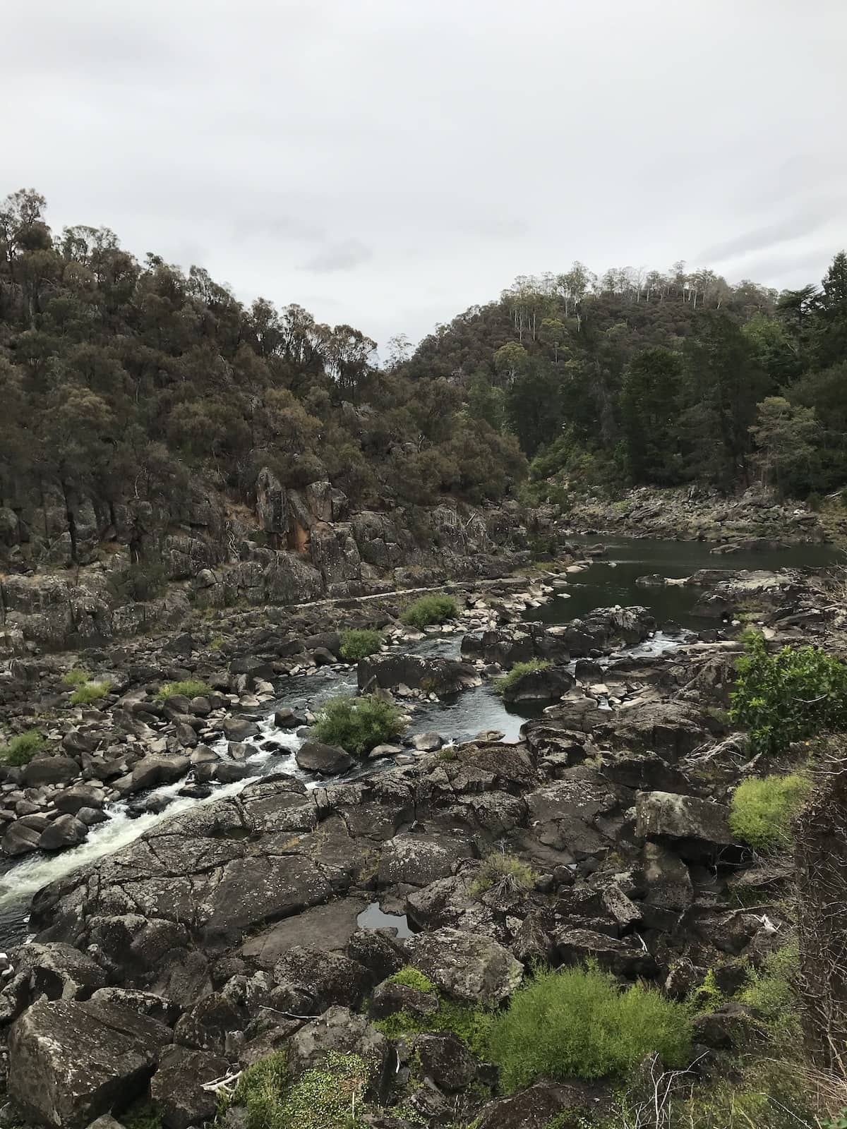 Another view from a high vantage point, of a river rushing past many rocks, as part of a gorge