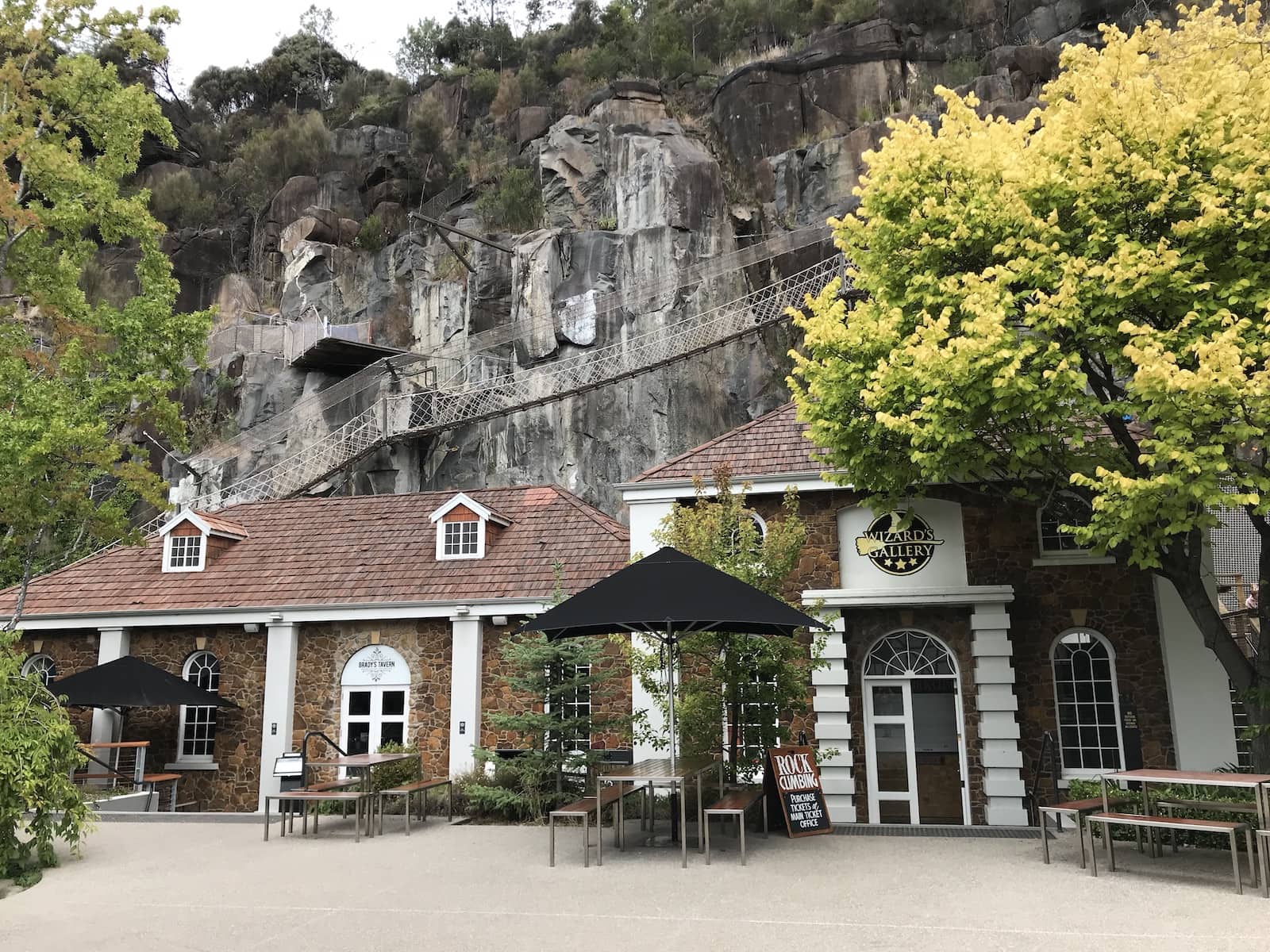 The front of cafes built in colonial style, in front of a rock face