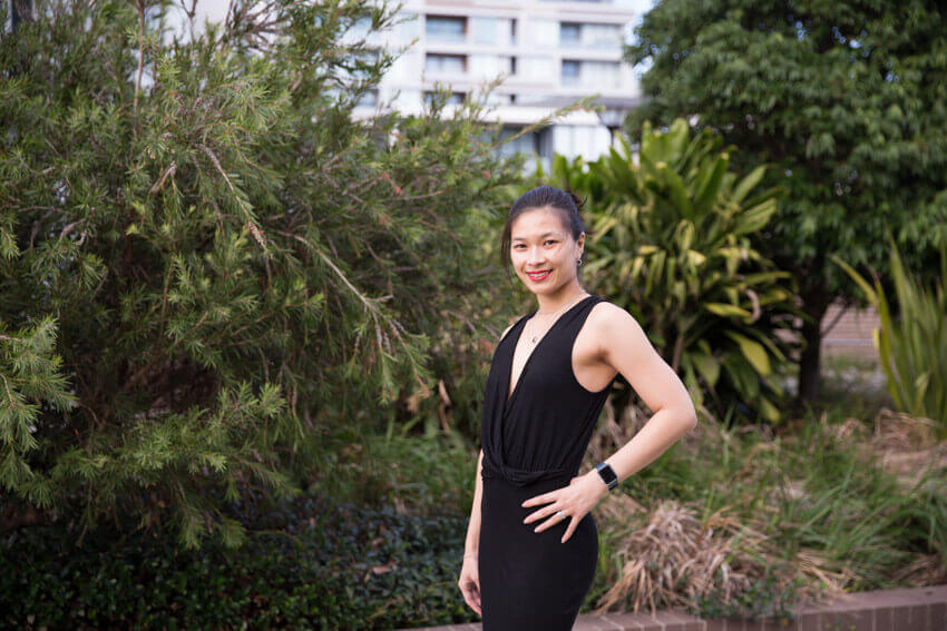 The same woman in the previous photo, wearing the same clothing and in the same setting. This is a closer shot, showing her from the waist up, smiling.