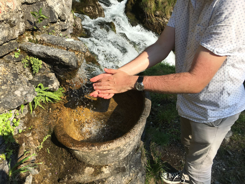 Nick washing his hands in a running fountain that used water from the waterfall