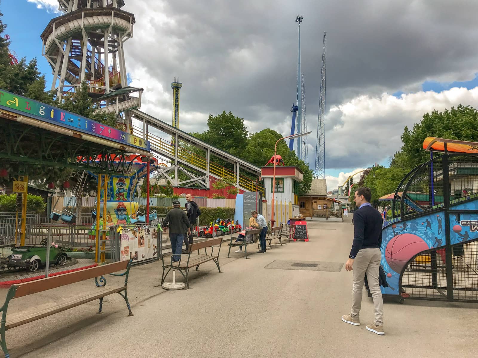 The inside of an amusement park. A few rides like cars on a track and rotating swings can be seen.