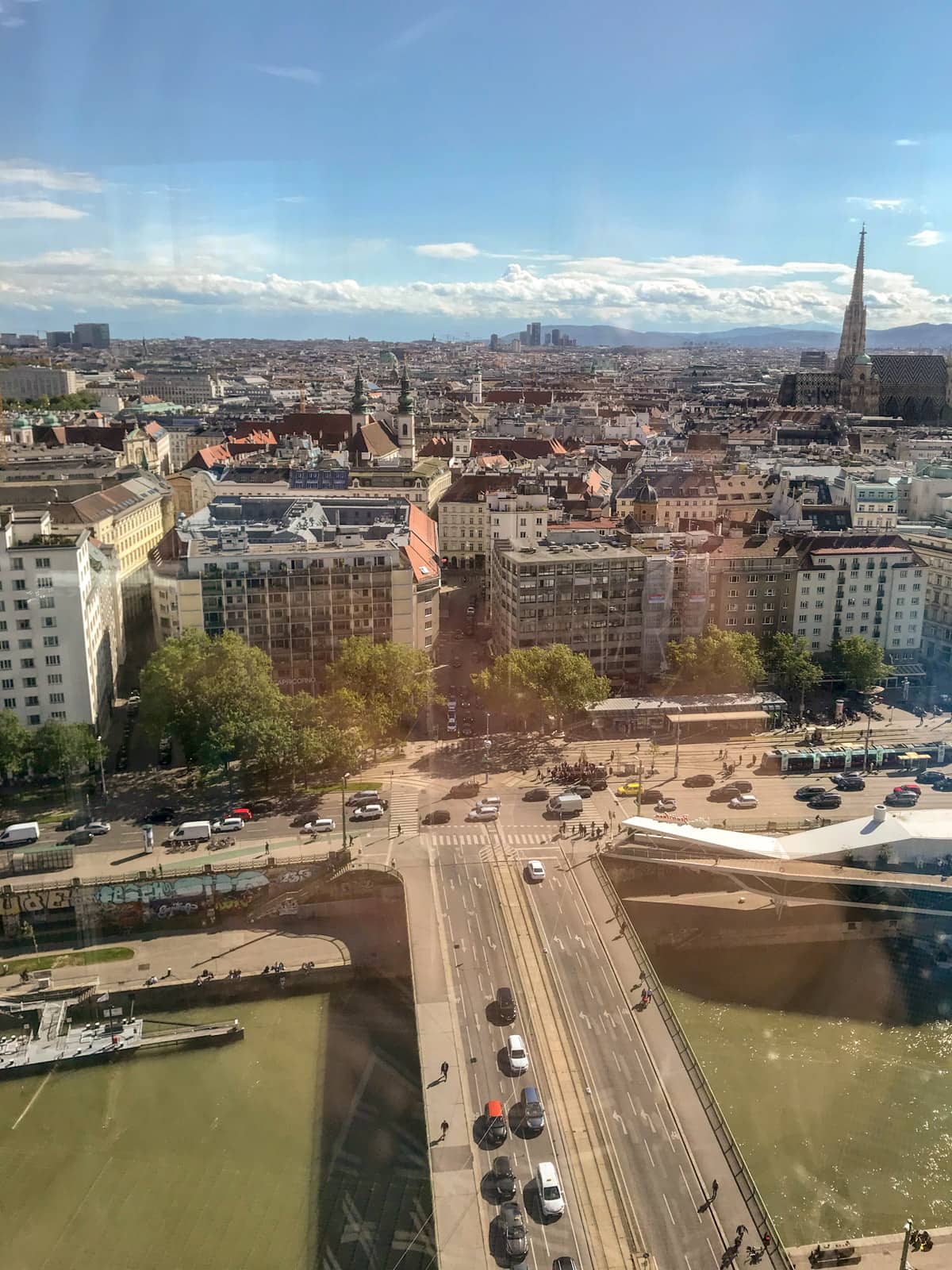 A view of the city of Vienna and its buildings, as seen from the glass window of a hotel