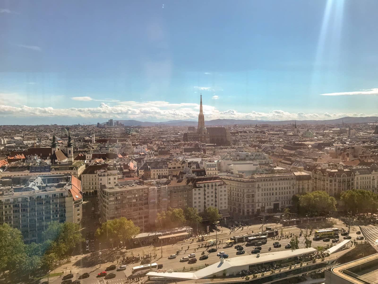 A landscape view of the city of Vienna as seen from the glass window of a hotel