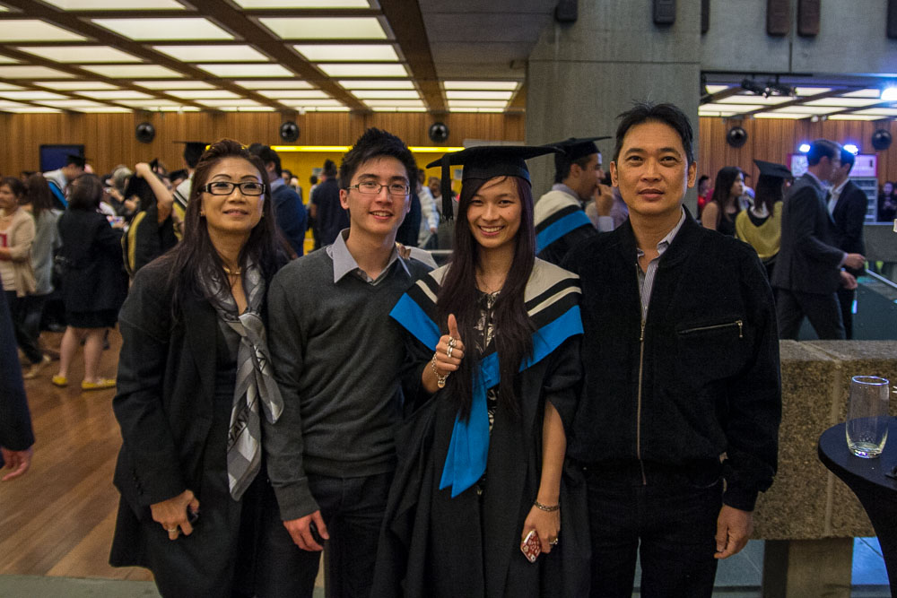 A young woman at her graduation ceremony with her mum, dad, and brother