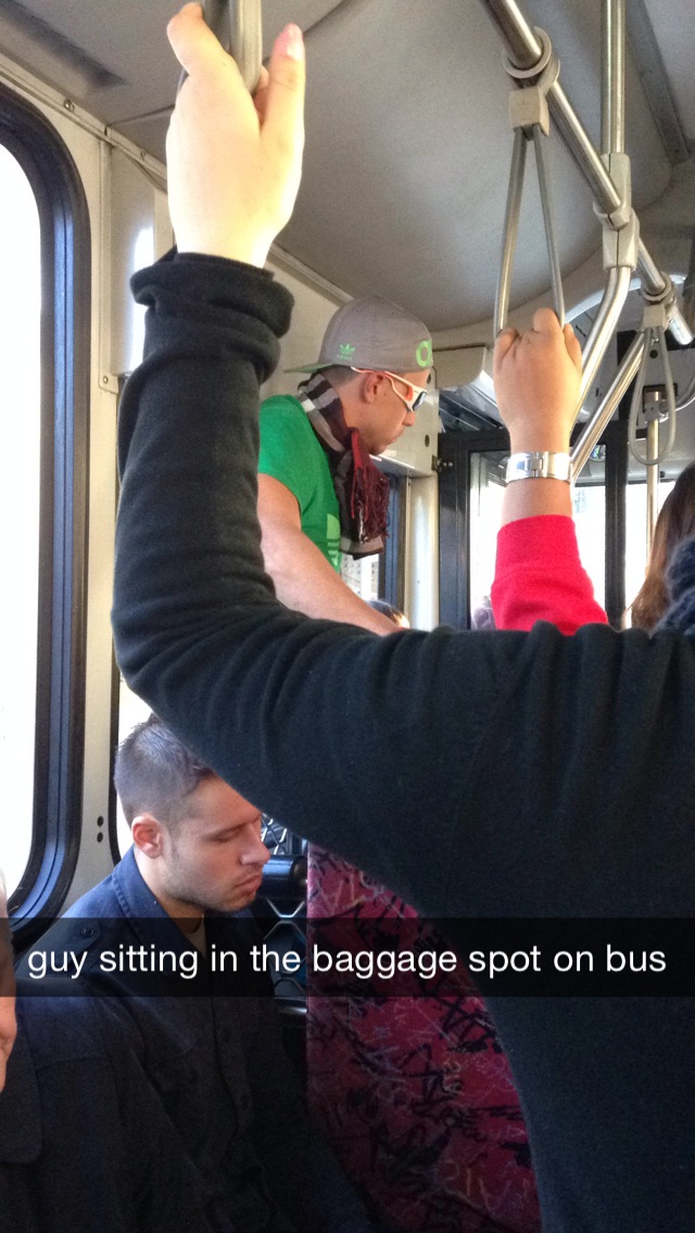 guy sitting in the baggage spot on bus