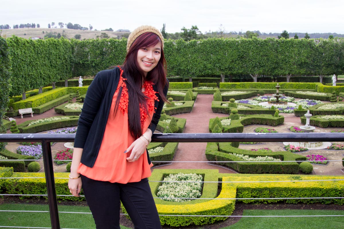 On a balcony with a garden in the background