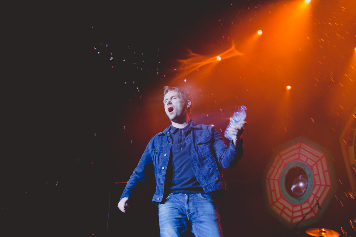 Damon Albarn throwing water from a water bottle