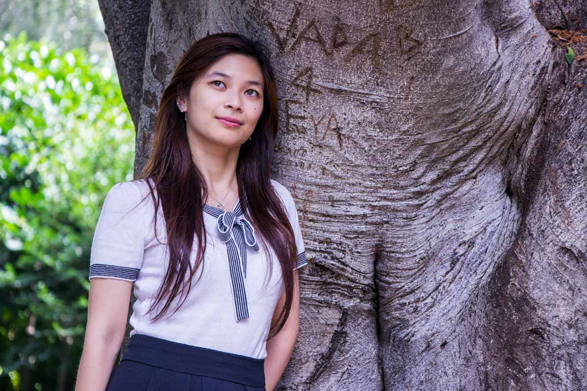 Leaning against a tree with some etchings in the trunk