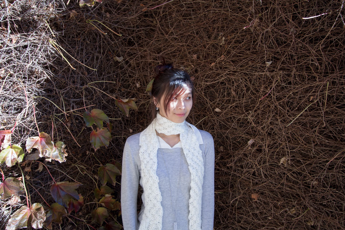 Standing in front of a run-down, winter-affected hedge